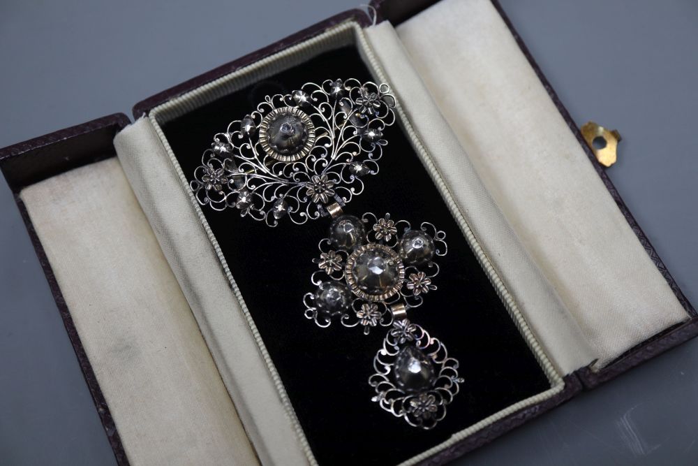 A continental pierced white and yellow metal, diamond set graduated three tier drop brooch, 79mm, gross 13.8 grams.